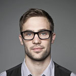 A well-dressed man with glasses and a vest