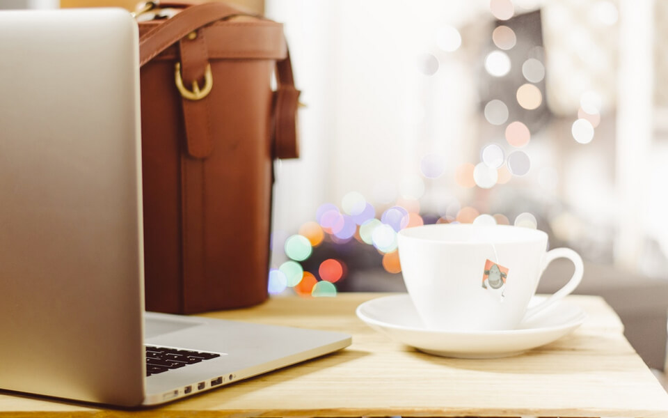 A laptop and coffee cup placed on a table, creating a cozy workspace for productivity and relaxation.