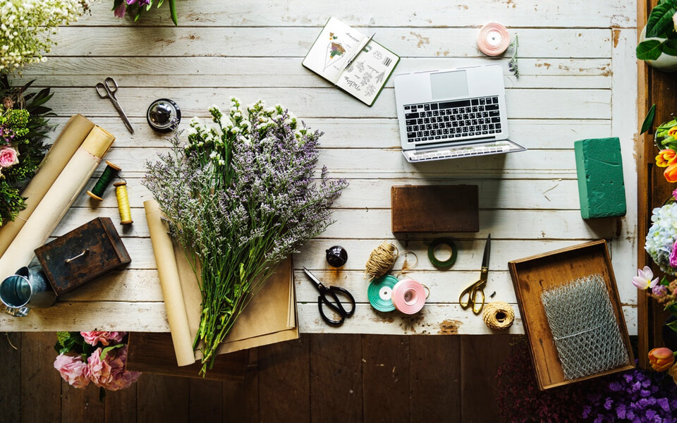 A table adorned with flowers, scissors, and various supplies, creating a vibrant and creative atmosphere.